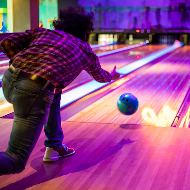 Man bowling at a bowling alley as part of customer experience research.