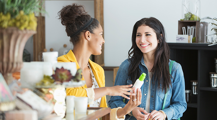 Two women taking to each other on which one girl is holding a product in her hand.